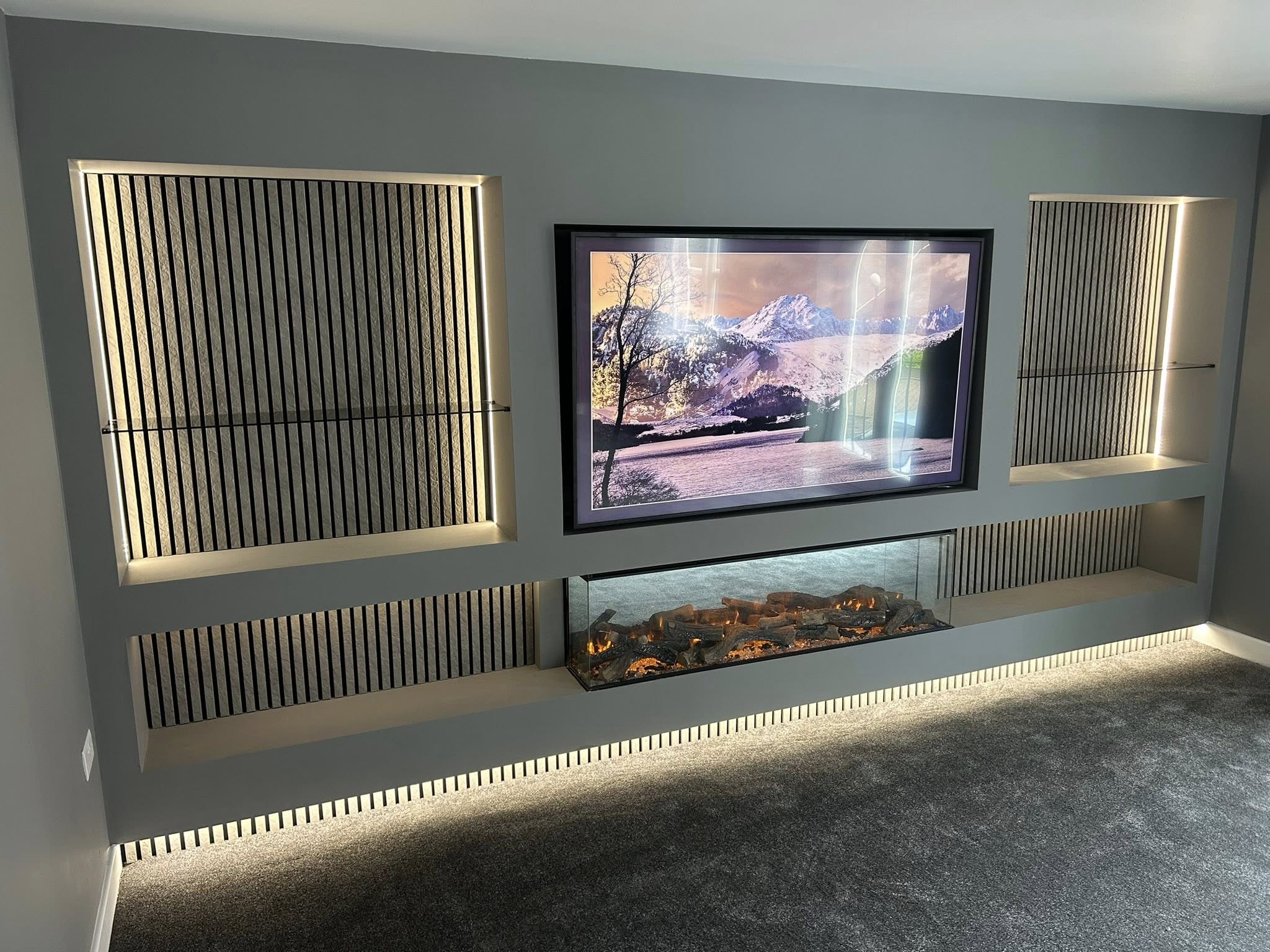 Large wide media wall with large selves and electric fire