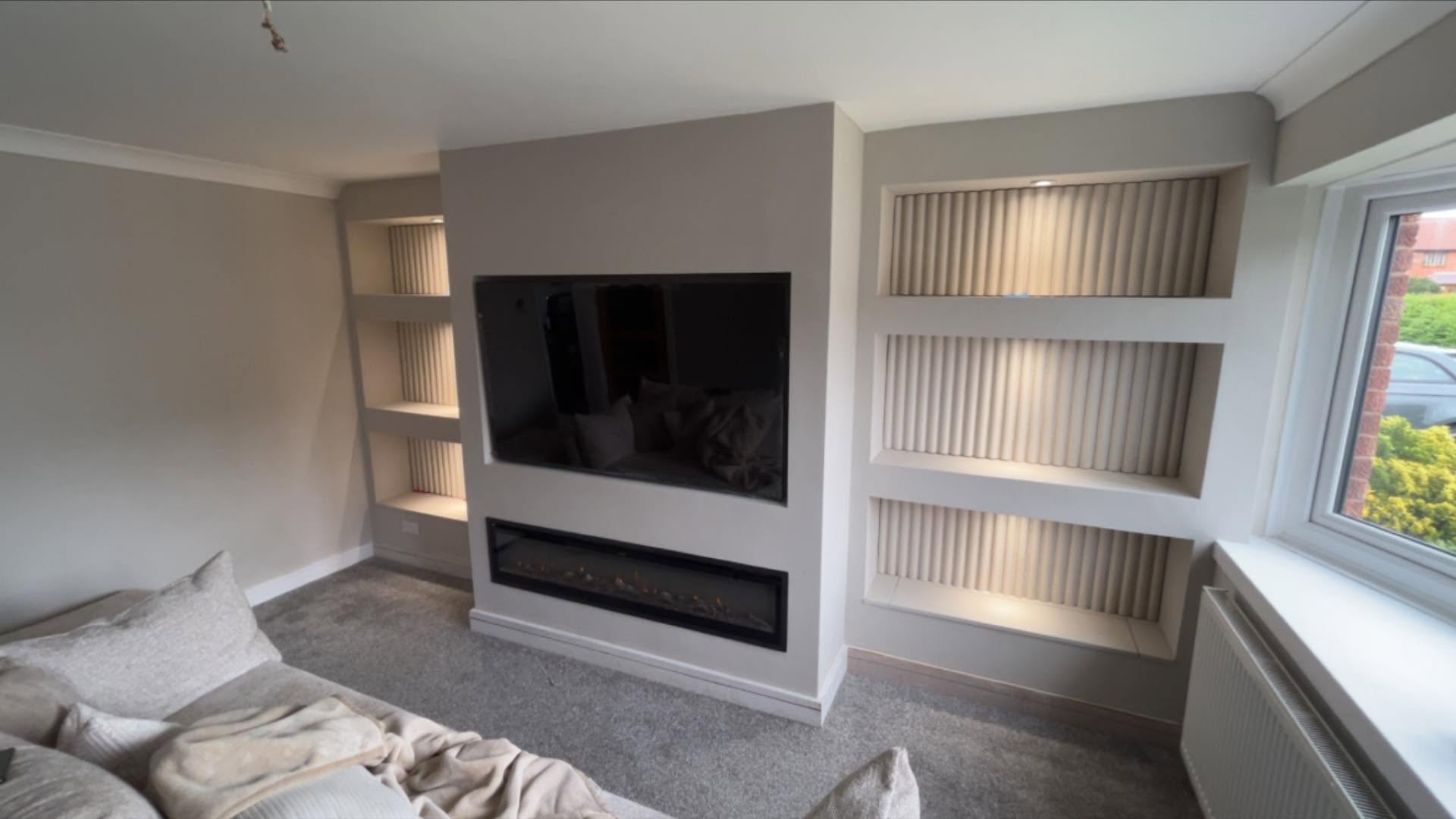 Empty media wall with large selves and fitted TV